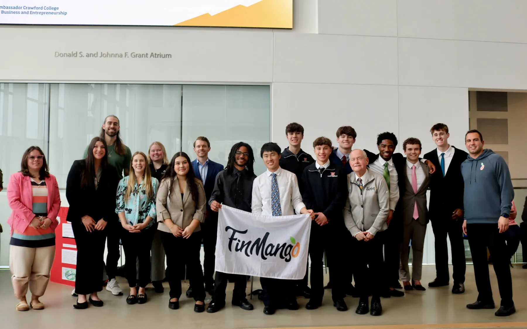 2026 Barrier Breakers Demo Day winners holding the FinMango banner in the Grant Atrium